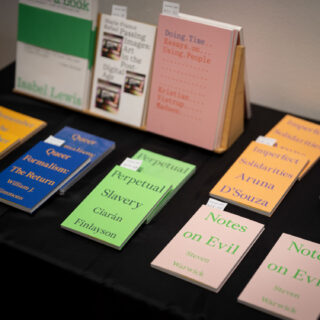 Various colourful books from Floating Opera Press are displayed on a table with black table cloth.