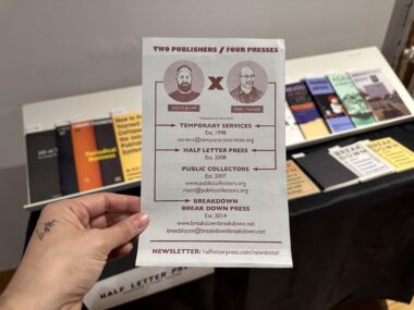 A light skinned hand holds a flyer reading "TWO PUBLISHERS / FOUR PRESSES" from Half Letter Press.