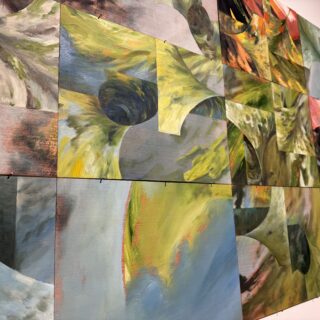 Close up of colourful abstract paintings on a white gallery wall